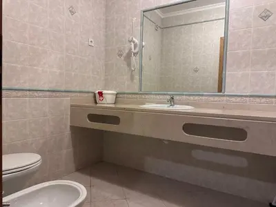 a bathroom with a sink and a toilet and a mirror at Sunset Bliss in Albufeira - Short walk to Oldtown in Albufeira