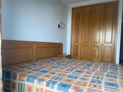 a bedroom with a bed and a wooden cabinet at Sunset Bliss in Albufeira - Short walk to Oldtown in Albufeira