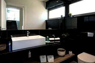 a bathroom with a white sink and a toilet at Luxury Beach Villa - Casa do Forte- Infinity Pool sea view- Beach walking distance by DreamvillasAlbufeira in Albufeira