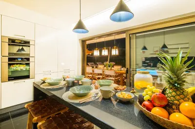 a kitchen with a counter with bowls of fruit on it at Luxury Beach Villa - Casa do Forte- Infinity Pool sea view- Beach walking distance by DreamvillasAlbufeira in Albufeira
