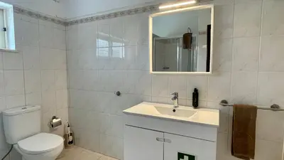 a bathroom with a toilet and a sink and a mirror at Falesia by Check-in Portugal in Albufeira