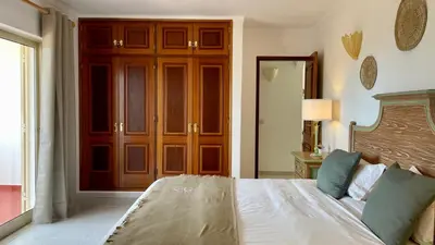 a bedroom with a large bed with a wooden headboard at Falesia by Check-in Portugal in Albufeira
