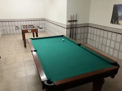 a green pool table in a room with a table at Falesia by Check-in Portugal in Albufeira
