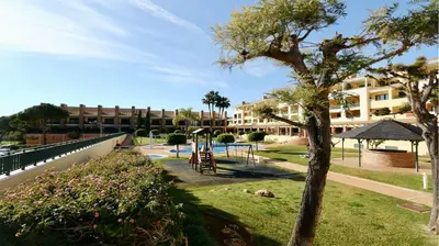 a playground in a park next to a building at Los Olivos Del Golf 249- CleverDetails, Sleeps 6 Adults 1 Child in Vilamoura