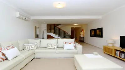 a living room with a white couch and a tv at Los Olivos Del Golf 249- CleverDetails, Sleeps 6 Adults 1 Child in Vilamoura