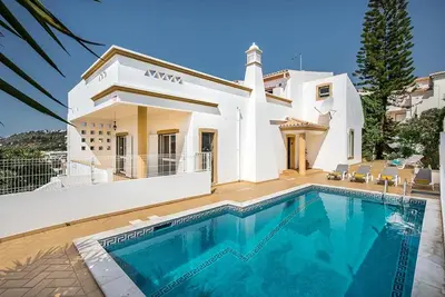 a villa with a swimming pool in front of a house at Villa Almanda - Spacious villa perfectly located between Albufeira Marina and the Old Town in Albufeira