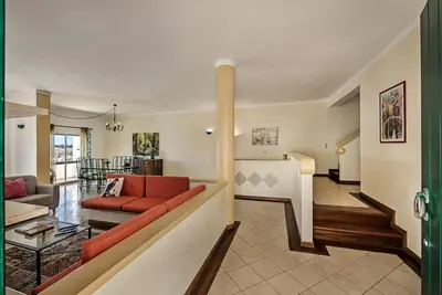 a living room with a red couch and a table at Villa Almanda - Spacious villa perfectly located between Albufeira Marina and the Old Town in Albufeira