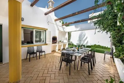 a dining table and chairs on a patio at Villa Almanda - Spacious villa perfectly located between Albufeira Marina and the Old Town in Albufeira