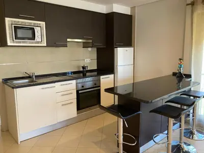 a kitchen with white cabinets and a black counter top at Vilamoura Apartamento Algarve 311 in Vilamoura