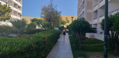 a woman walking down a sidewalk next to a building at Vilamoura Apartamento Algarve 311 in Vilamoura