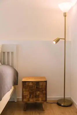 a lamp sitting next to a bed next to a table at Starry Nights Apartment in Albufeira