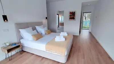 a bedroom with a large white bed and a table at Valverde 3 Villa, Vilamoura, Algarve, only 5 minutes from Marina, Golf and Beach in Quarteira