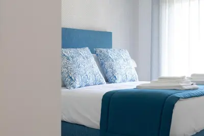a bedroom with a bed with blue and white pillows at Orange Boutique Residence - Casa Luis Camões in Quarteira