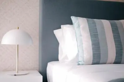 a bed with a pillow and a lamp on a table at Orange Boutique Residence - Casa Luis Camões in Quarteira