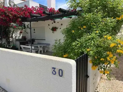 a house with flowers on the side of it at Green House by FHR estacionamento e WI-FI in Quarteira