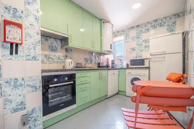 a kitchen with green cabinets and a red stool at Al Marina View Uma - Lux apartment on the marina in Páteo