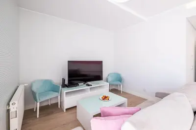 a living room with a couch and a tv at Al Marina View Uma - Lux apartment on the marina in Páteo