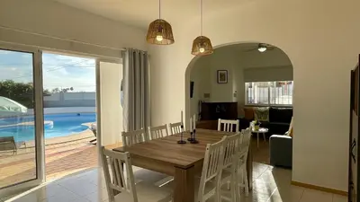 a dining room with a wooden table and a living room at Nicola by Check-in Portugal in Albufeira