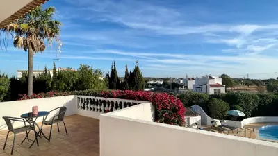 a patio with chairs and flowers on a white wall at Nicola by Check-in Portugal in Albufeira