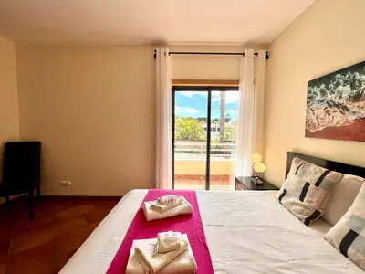 a bedroom with a bed and a large window at Albufeira Experience With Pool by Homing in Albufeira