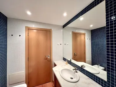 a blue tiled bathroom with a toilet and a shower at Albufeira Experience With Pool by Homing in Albufeira