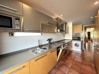 a kitchen with stainless steel appliances and brown cabinets at Albufeira Experience With Pool by Homing in Albufeira