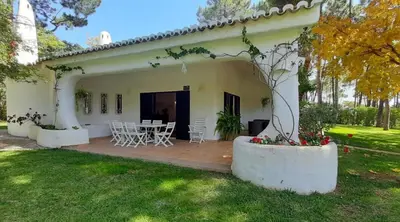 a house with a patio with a table and chairs at Villa Pinhal- Beautiful Villa located in quiet area in Quarteira