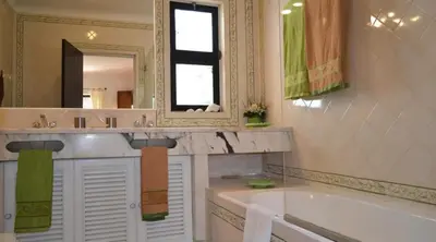 a bathroom with a tub and a sink and a mirror at Villa Pinhal- Beautiful Villa located in quiet area in Quarteira