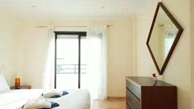 a bedroom with a bed and a mirror and a dresser at Divine Quarteira Sea View By JG Apartments in Quarteira