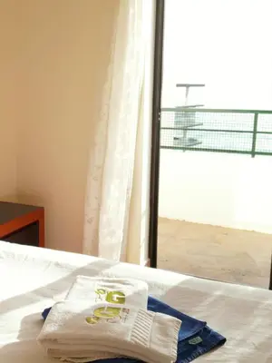 a pair of towels sitting on a bed with a window at Divine Quarteira Sea View By JG Apartments in Quarteira