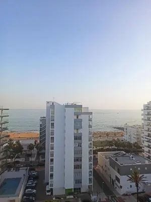 a tall white building with the ocean in the background at Divine Quarteira Sea View By JG Apartments in Quarteira