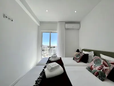 a white room with a bed and a window at Faro Deluxe by Homing in Faro