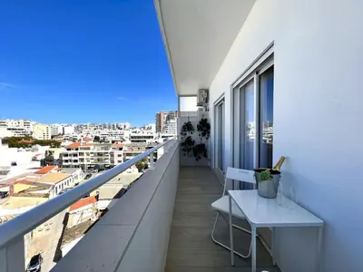 a balcony with a bench and a view of a city at Faro Deluxe by Homing in Faro