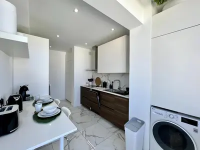 a white kitchen with a washing machine in it at Faro Deluxe by Homing in Faro
