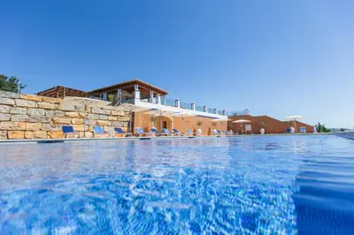 a swimming pool in front of a house at Shantivillas Malhão in Azinhal