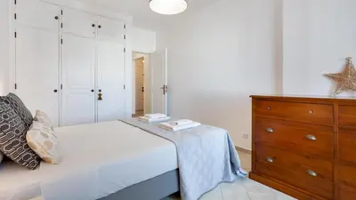 a bedroom with a bed and a wooden dresser at Sun-kissed Oasis W/ Pool by LovelyStay in Albufeira