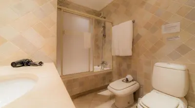 a bathroom with a toilet and a sink and a shower at Villa Bonsal - Modern villa in a prime location near the luxury golf courses in Albufeira