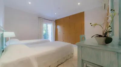 a bedroom with a bed and a table with a plant on it at Villa Bonsal - Modern villa in a prime location near the luxury golf courses in Albufeira