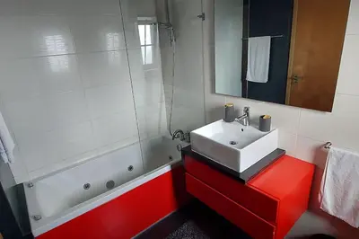 a bathroom with a white sink and a red cabinet at Baia Village - Galé - Albufeira in Albufeira