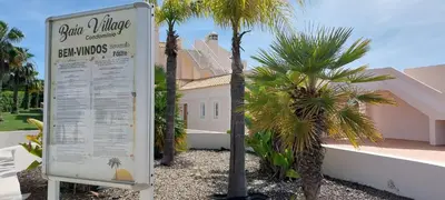 a sign in front of a house with palm trees at Baia Village - Galé - Albufeira in Albufeira