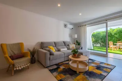 a living room with a couch and a table and chairs at Lemon House - 400m from the Beach - Wifi in Albufeira