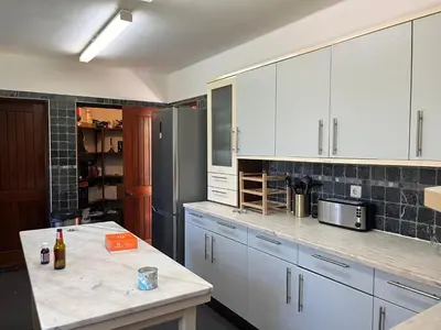 a kitchen with white cabinets and a stainless steel refrigerator at Villa Amarela in Vilamoura