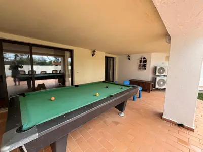 a living room with a pool table in it at Villa Amarela in Vilamoura