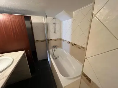 a bathroom with a bath tub and a sink at Villa Amarela in Vilamoura