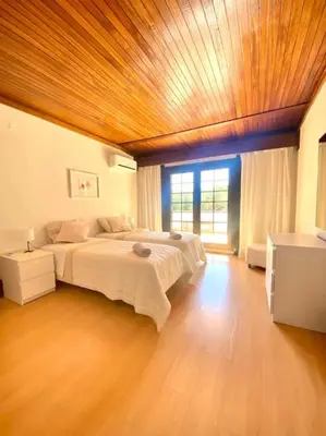 a bedroom with a large bed and a wooden ceiling at Vila Alice in Quarteira
