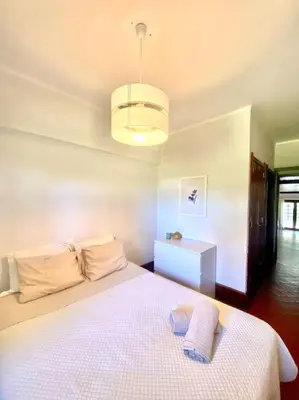 a bedroom with a white bed and a light at Vila Alice in Quarteira