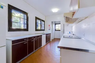 a large kitchen with brown cabinets and white counter tops at Vila Alice in Quarteira