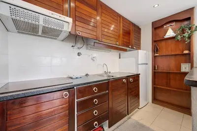 a kitchen with wooden cabinets and a sink and a refrigerator at House Amendoeiras in Vilamoura