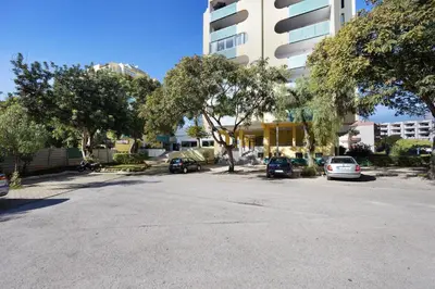 a parking lot with cars parked in front of a building at House Amendoeiras in Vilamoura