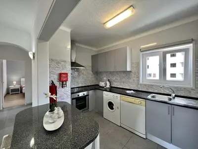 a kitchen with a table with a vase of flowers on it at Vilamoura Central 5 by Homing in Vilamoura
